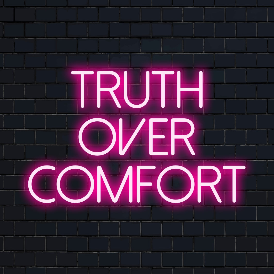 LED-valokyltti, jossa on lihavoitu valkoinen teksti, Truth Over Comfort, joka esittelee minimalistista ja tyylikästä neonvaloa.