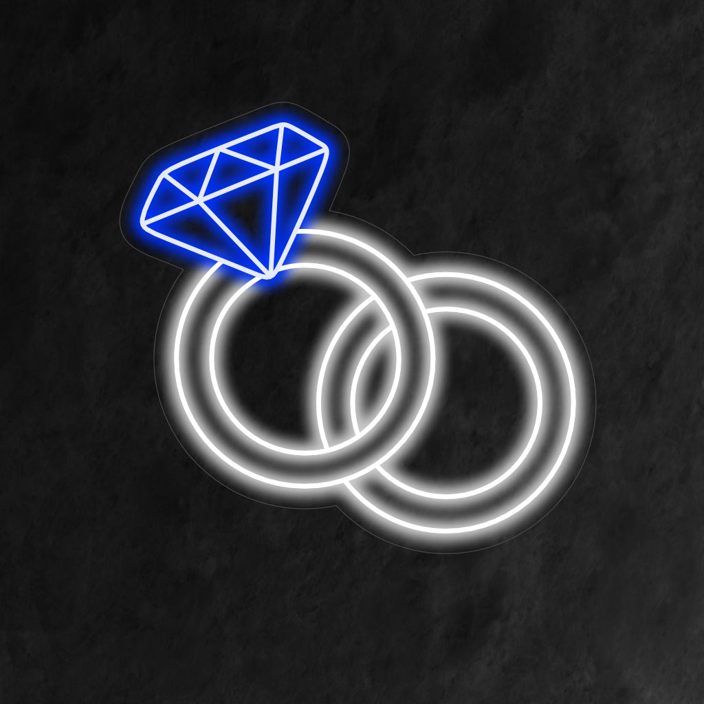"Wedding Rings Neon Sign" symboloi ikuista rakkautta pehmeällä hehkulla, luoden romanttisen ilmapiirin, joka juhlii kahden sydämen liittoa.