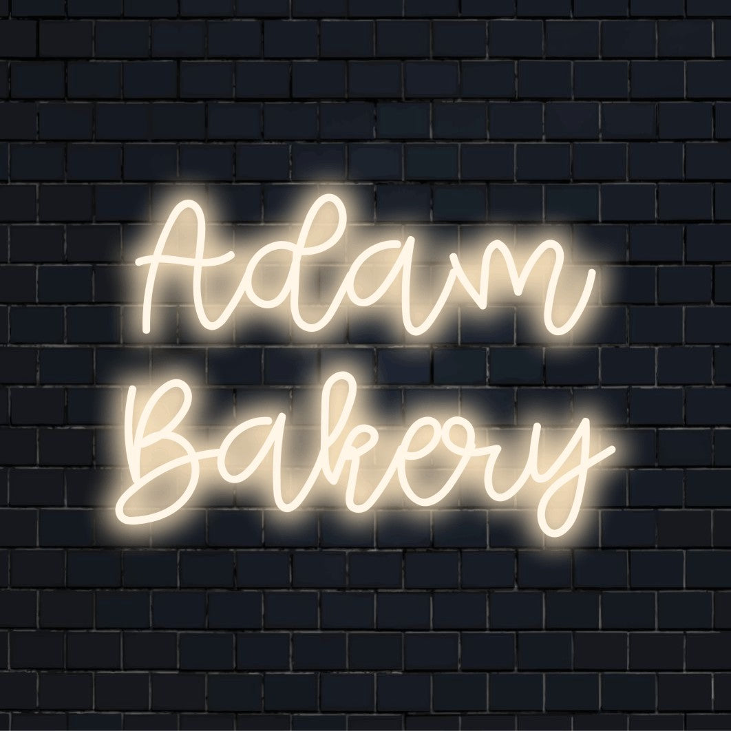 Adam Bakery Personalized LED Neon Sign, soft neon glow against black brick wall