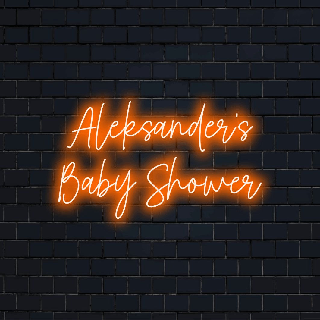 Aleksander_s Baby Shower Custom Name Neon Sign, glowing lettering on dark brick wall