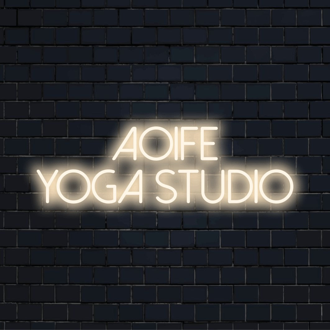 Aoife Yoga Studio Personalized Neon Light with bright neon glow on black brick background