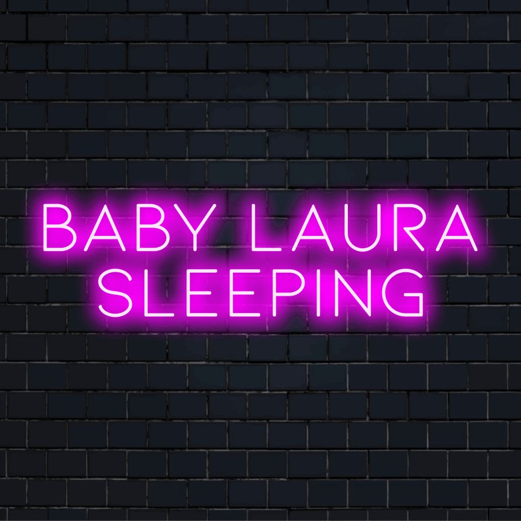 Baby Laura Sleeping Custom Name Neon Sign, glowing neon text against black brick wall