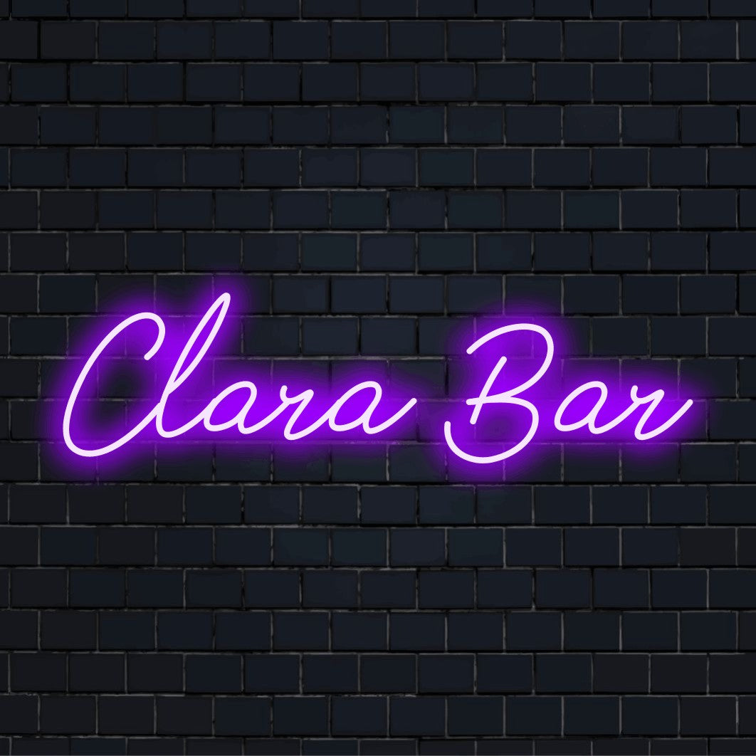 Clara Bar Personalized Neon Light with bright neon lettering against black brick wall