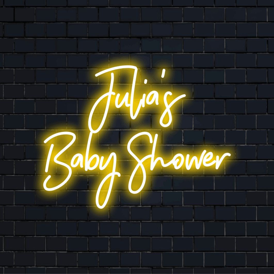 Julia_s Baby Shower Custom Name Neon Sign, glowing lettering against brick backdrop
