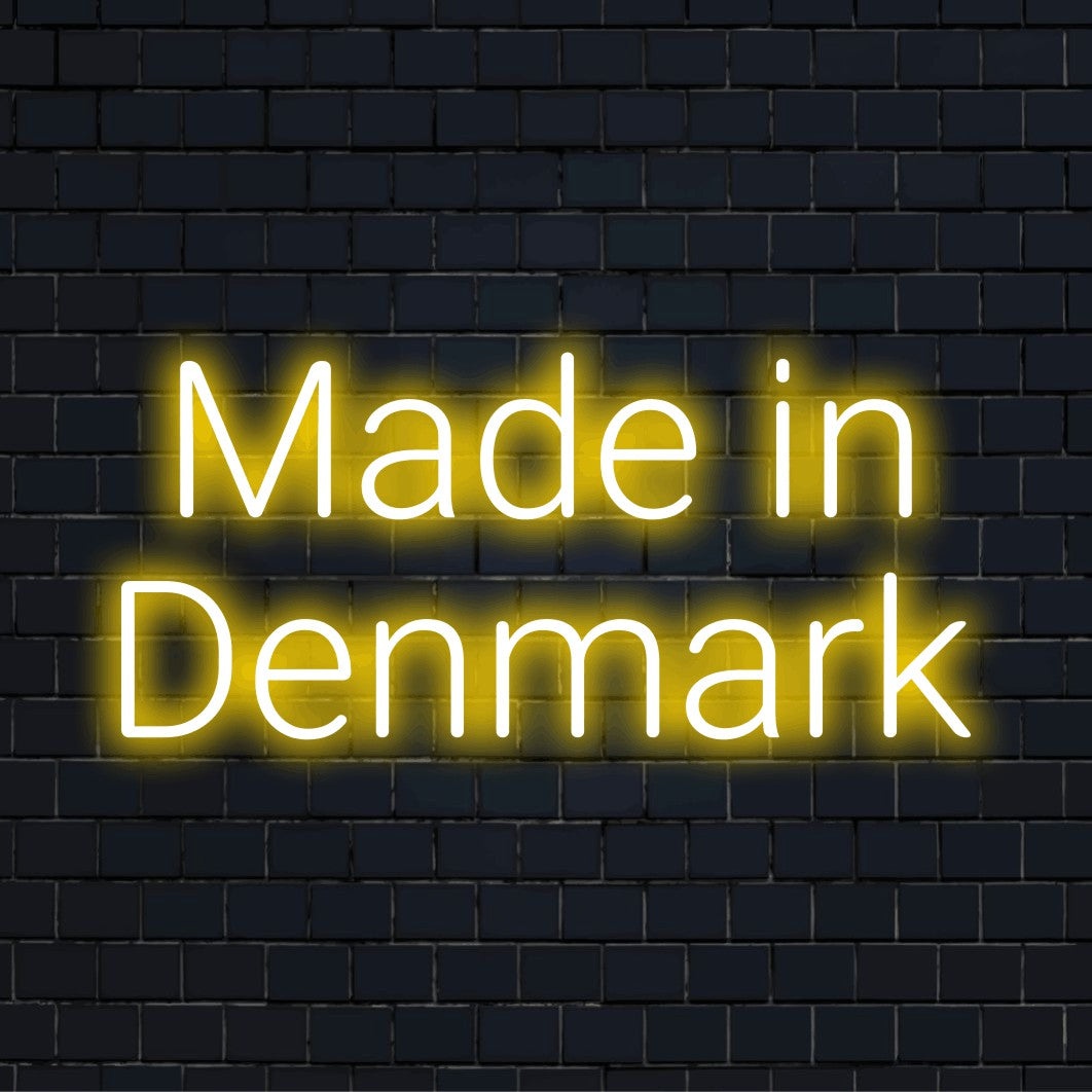Made In Denmark LED Neon Sign, glowing wall decor on dark brick background