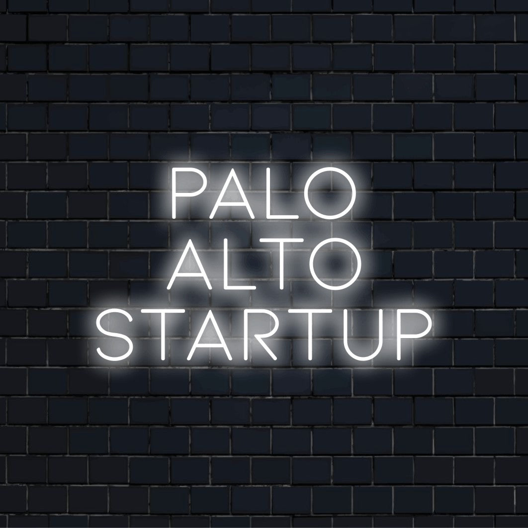 Palo Alto Startup Neon Sign, glowing lettering on dark brick wall