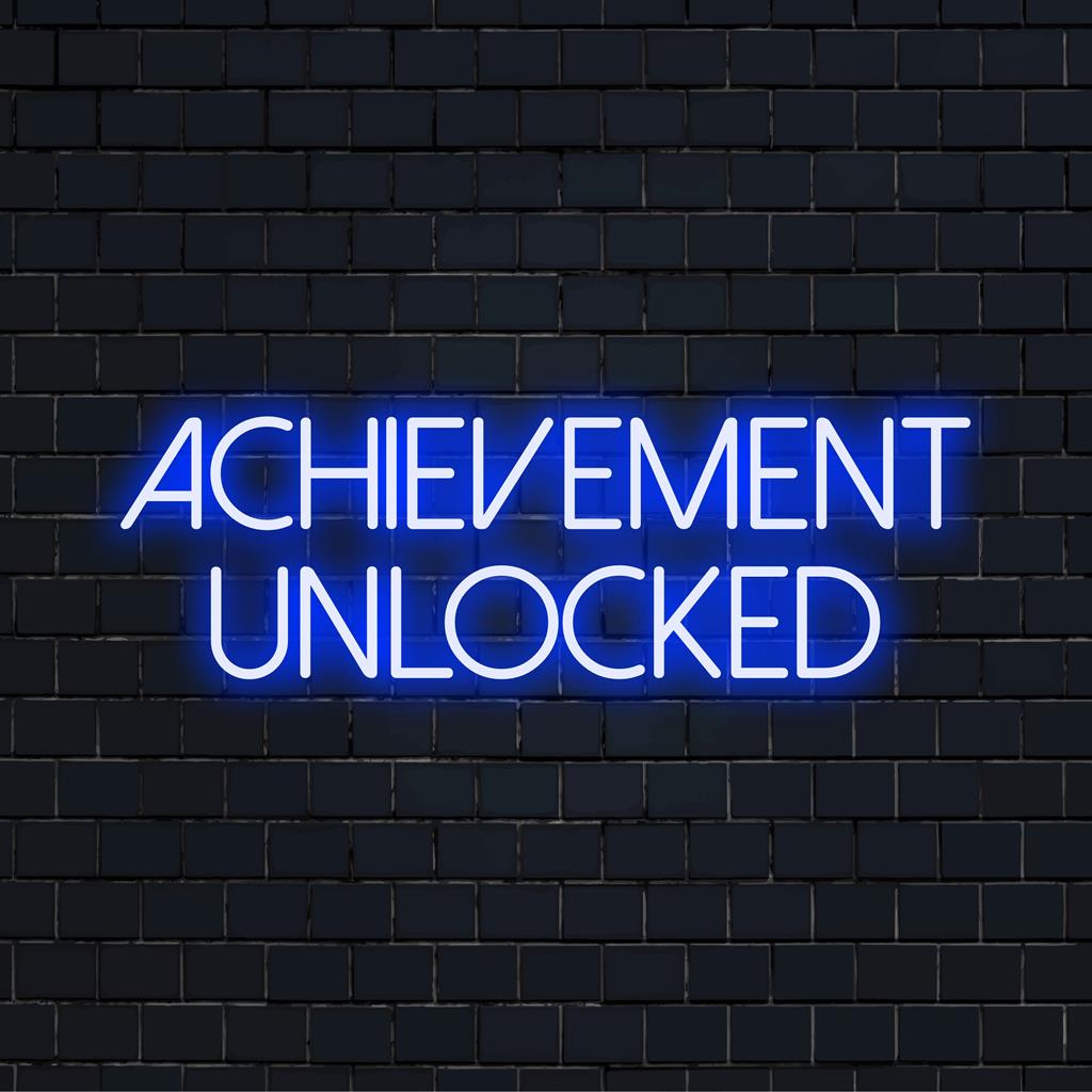 Eloisa LED-neonkyltti hehkuvalla tekstillä Achievement Unlocked, täydellinen energisoimaan mitä tahansa tilaa modernilla designilla.