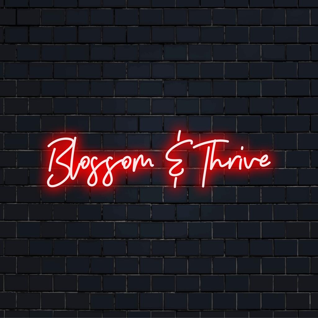 LED-neonkyltti, jossa on "Blossom And Thrive" eloisissa väreissä, ja se on täydellinen inspiroivaan neontaiteeseen ja -sisustukseen.