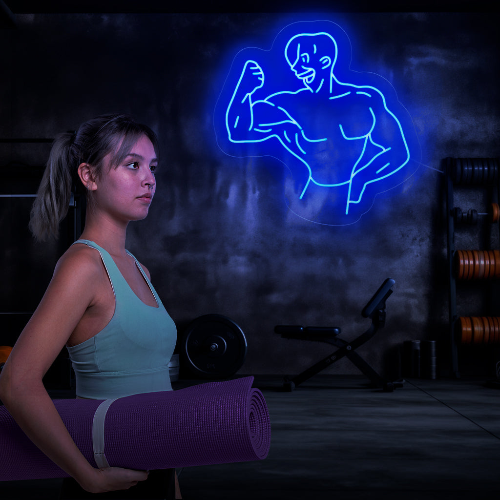 "Bodybuilder Neon Sign" - Tehokas neonvalo, jossa on lihaksikkaan kehonrakentajan siluetti ja joka tuo voimaa ja päättäväisyyttä kuntosaliisi tai kuntotilaan.