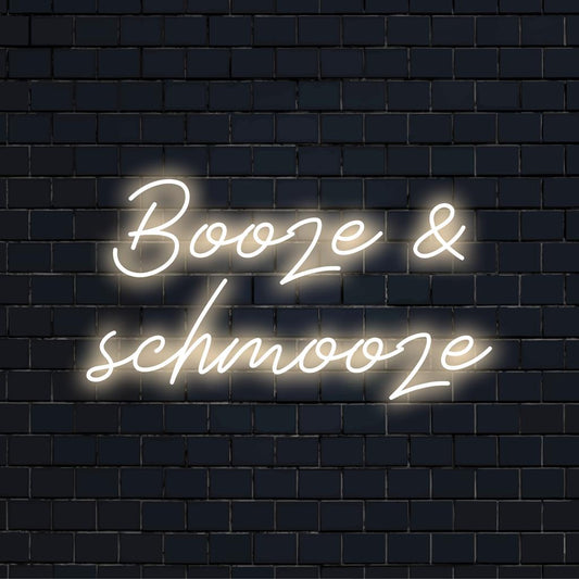 Vibrant 'Booze And Schmooze' custom LED neon sign, perfect for eclectic decor and lively gatherings. Neon quote art.