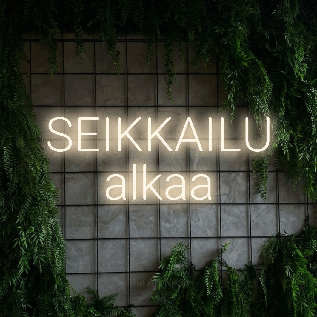 LED neon sign reading “SEIKKAILU alkaa”, arranged in 2 lines.