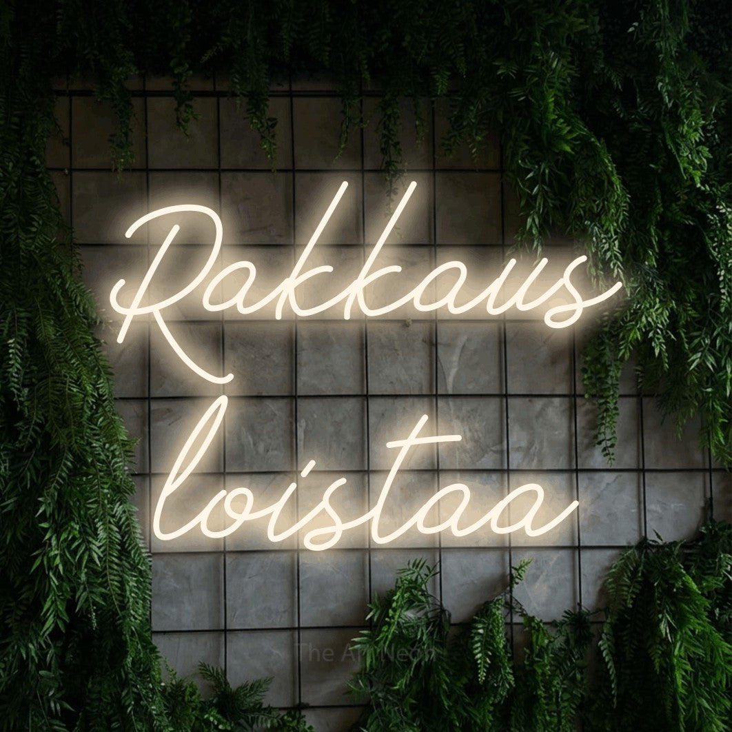 LED neon sign reading “Rakkaus loistaa”, arranged in 2 lines.