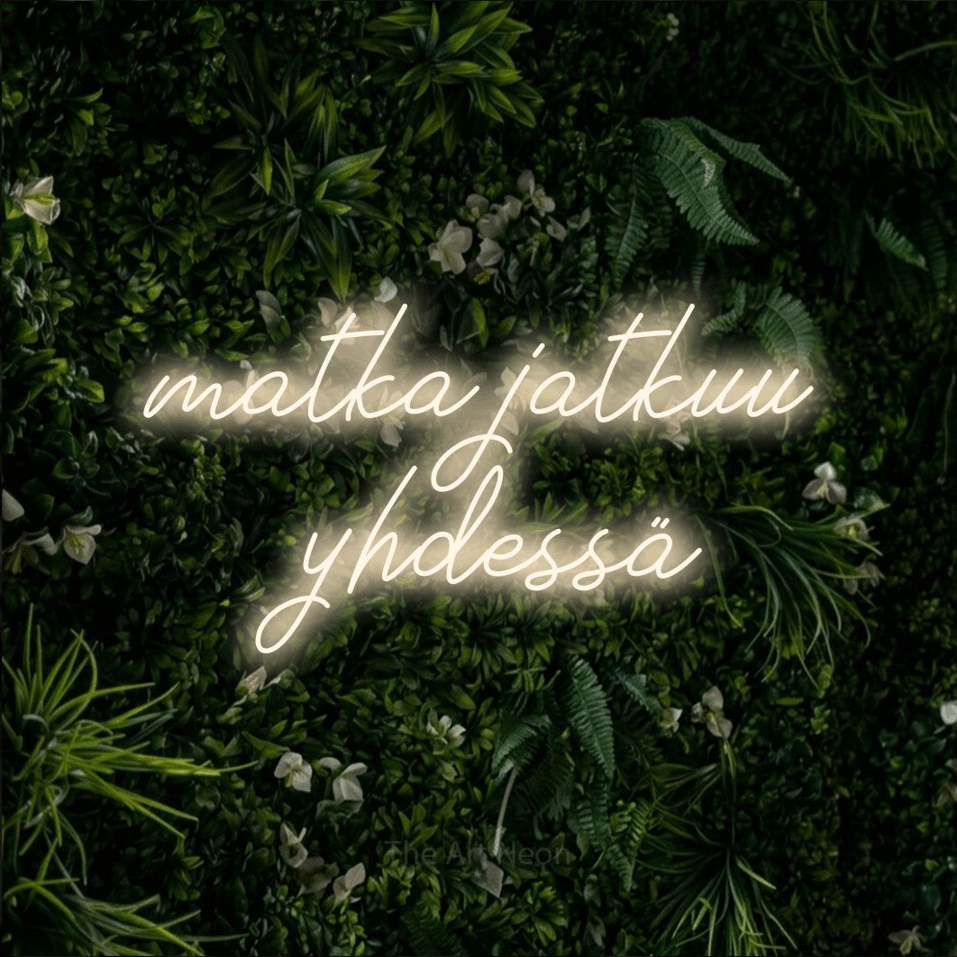 LED neon sign reading “matka jatkuu yhdessä”, arranged in 2 lines.
