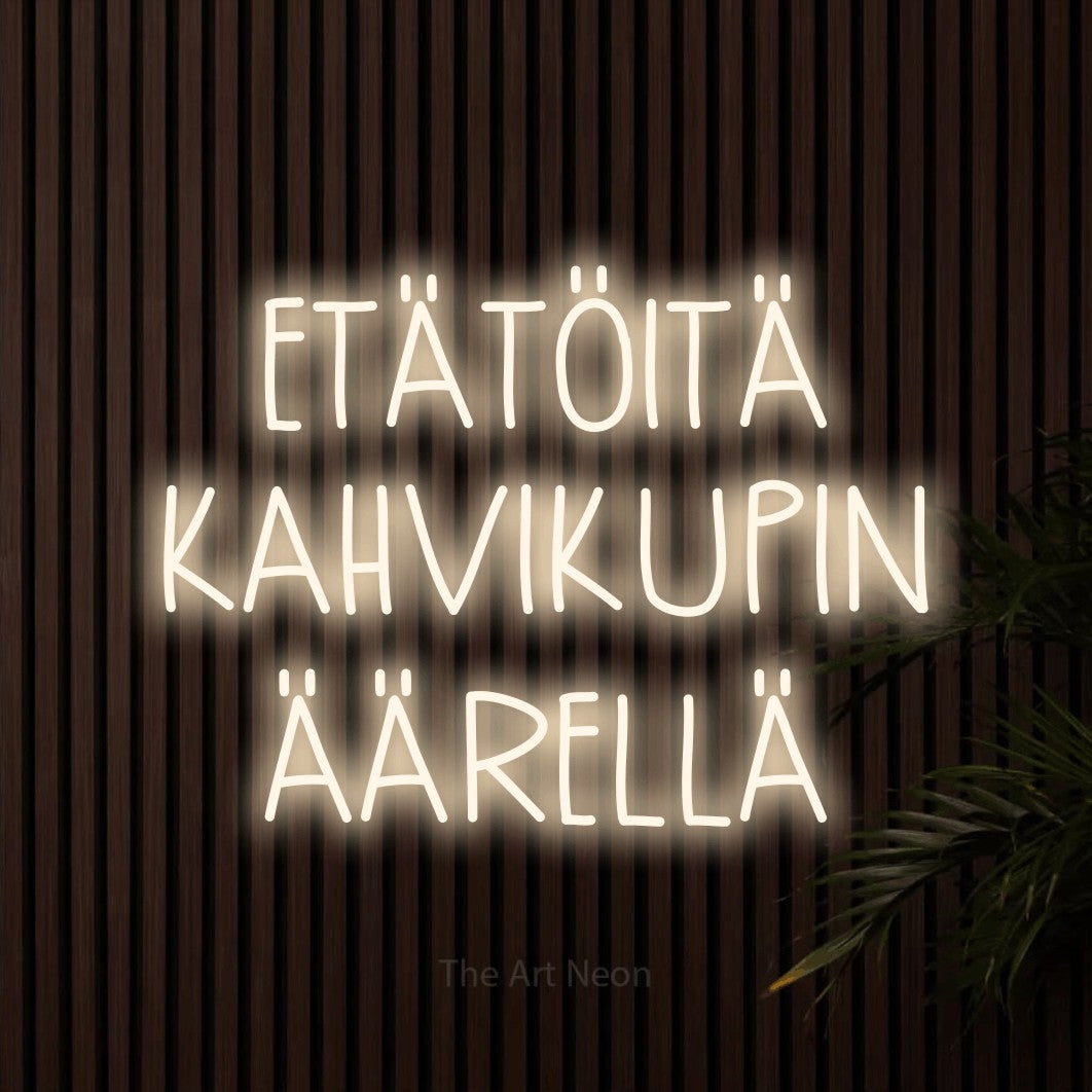LED neon sign reading “ETÄTÖITÄ KAHVIKUPIN ÄÄRELLÄ”, arranged in 3 lines.