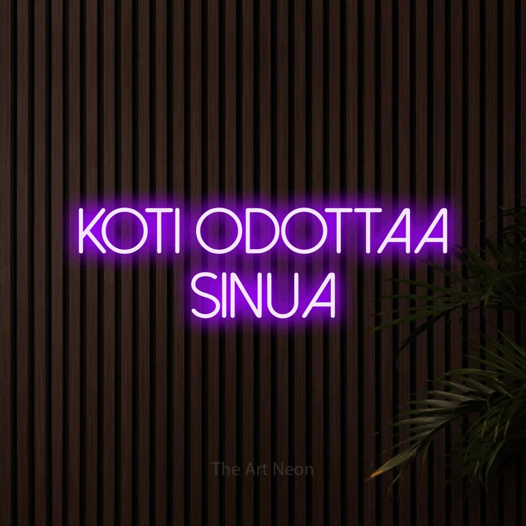 LED neon sign reading “KOTI ODOTTAA SINUA”, arranged in 2 lines.