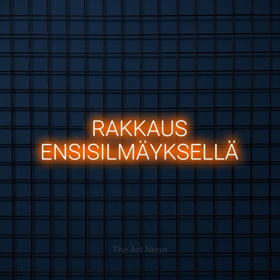 LED neon sign reading “RAKKAUS ENSISILMÄYKSELLÄ”, arranged in 2 lines.