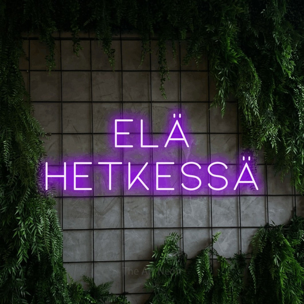 LED neon sign reading “ELÄ HETKESSÄ”, arranged in 2 lines.