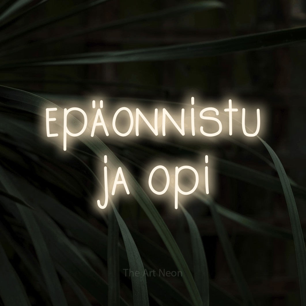 LED neon sign reading “epäonnistu ja opi”, arranged in 2 lines.