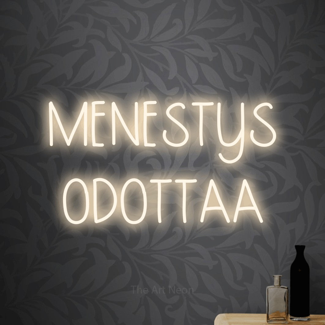 LED neon sign reading “MENESTYS ODOTTAA”, arranged in 2 lines.