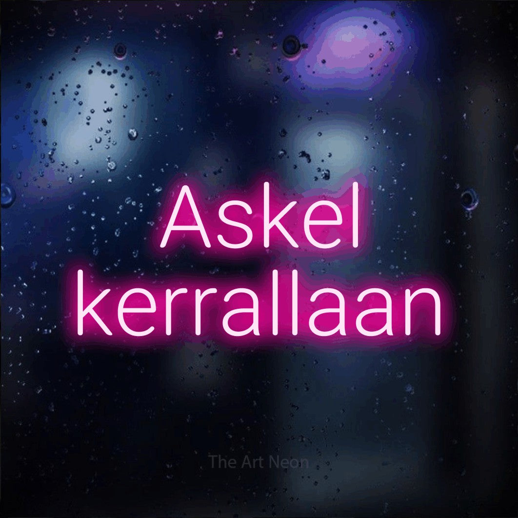 LED neon sign reading “Askel kerrallaan”, arranged in 2 lines.