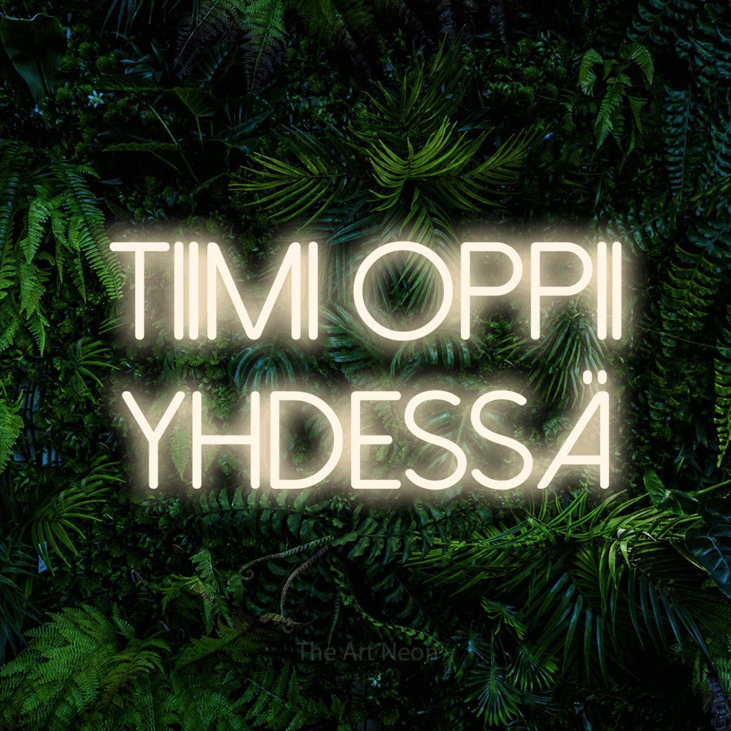 LED neon sign reading “Tiimi oppii yhdessä”, arranged in 2 lines.
