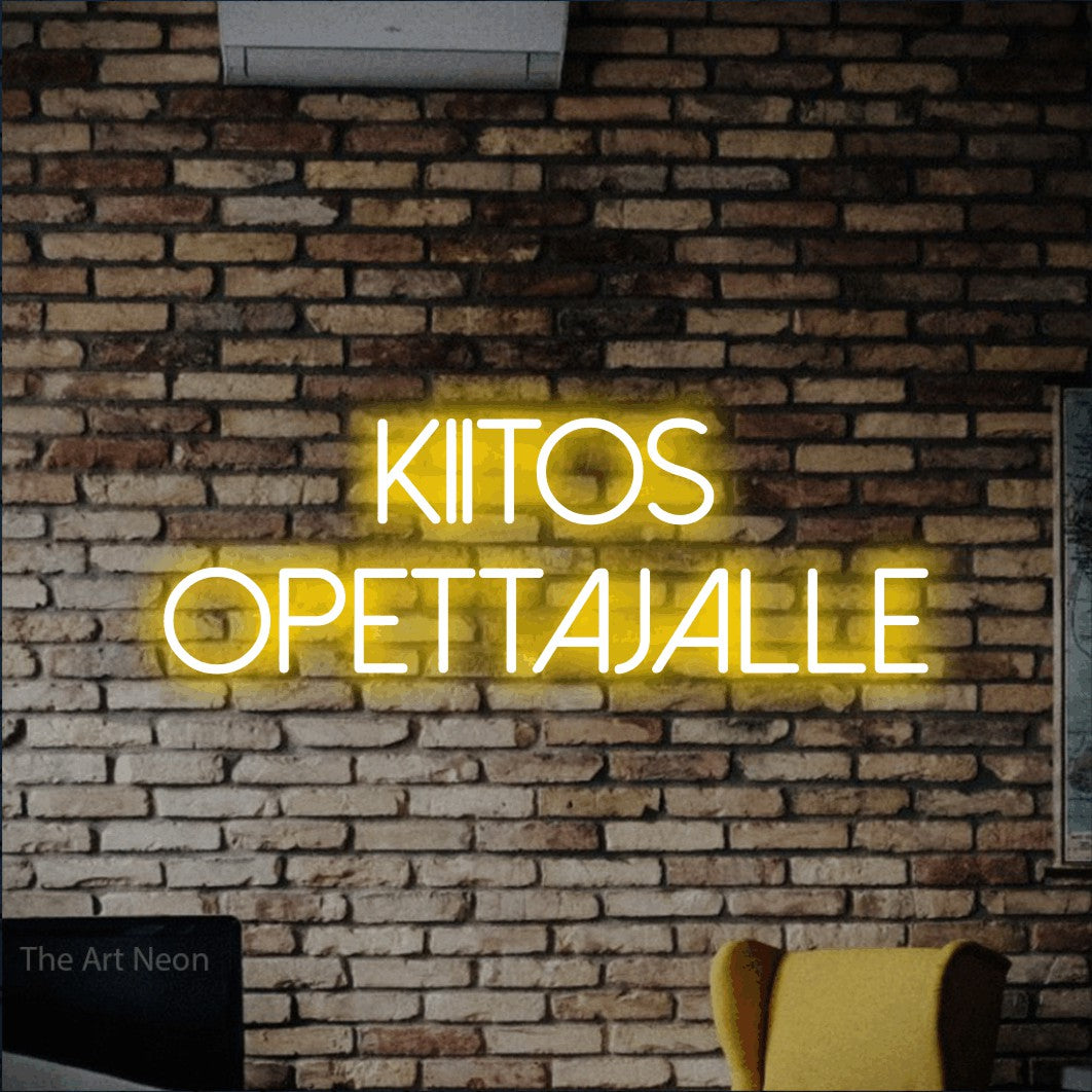 LED neon sign reading “Kiitos opettajalle”, arranged in 2 lines.