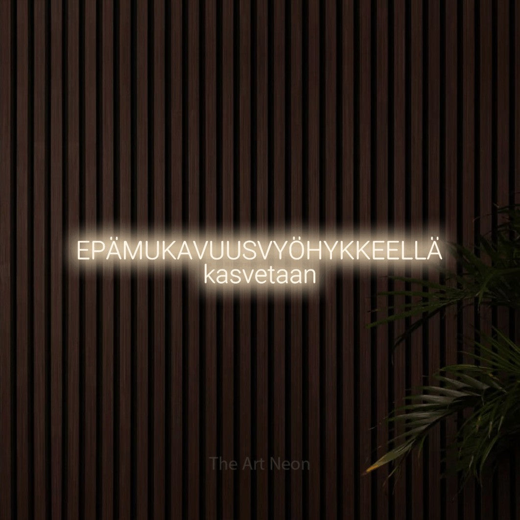 LED neon sign reading “EPÄMUKAVUUSVYÖHYKKEELLÄ kasvetaan”, arranged in 2 lines.