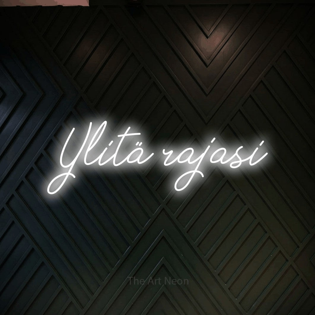 LED neon sign reading “Ylitä rajasi”, arranged in a single line.