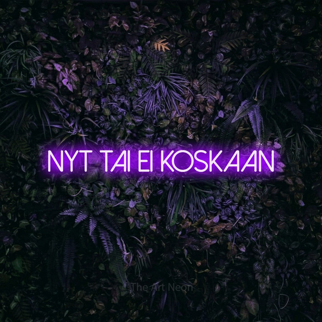 LED neon sign reading “Nyt tai ei koskaan”, arranged in a single line.