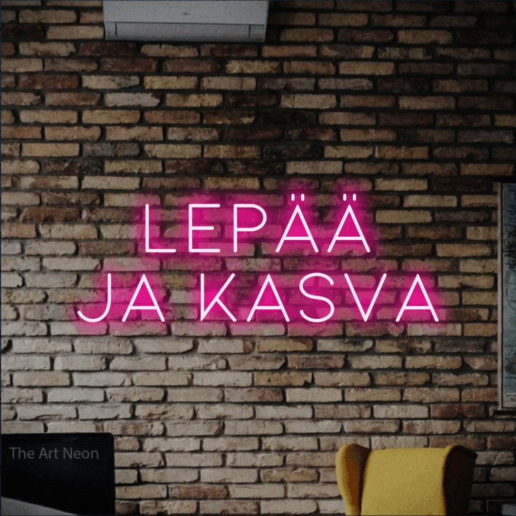 LED neon sign reading “Lepää ja kasva”, arranged in 2 lines.