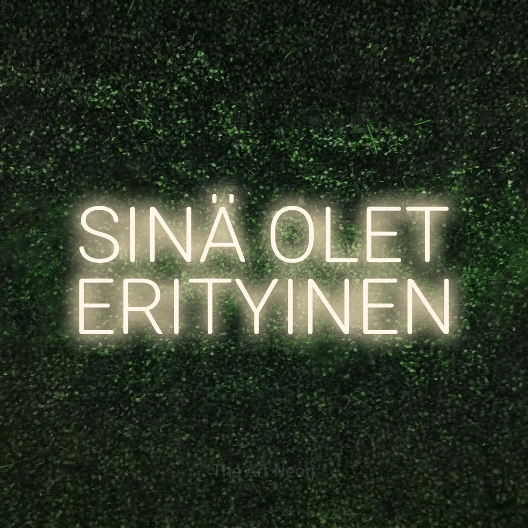 LED neon sign reading “SINÄ OLET ERITYINEN”, arranged in 2 lines.