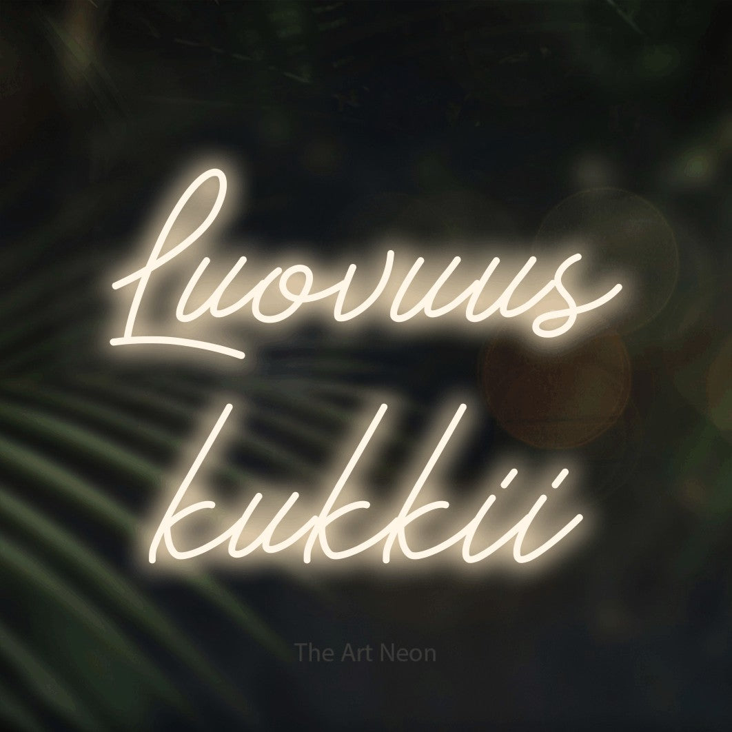 LED neon sign reading “Luovuus kukkii”, arranged in 2 lines.