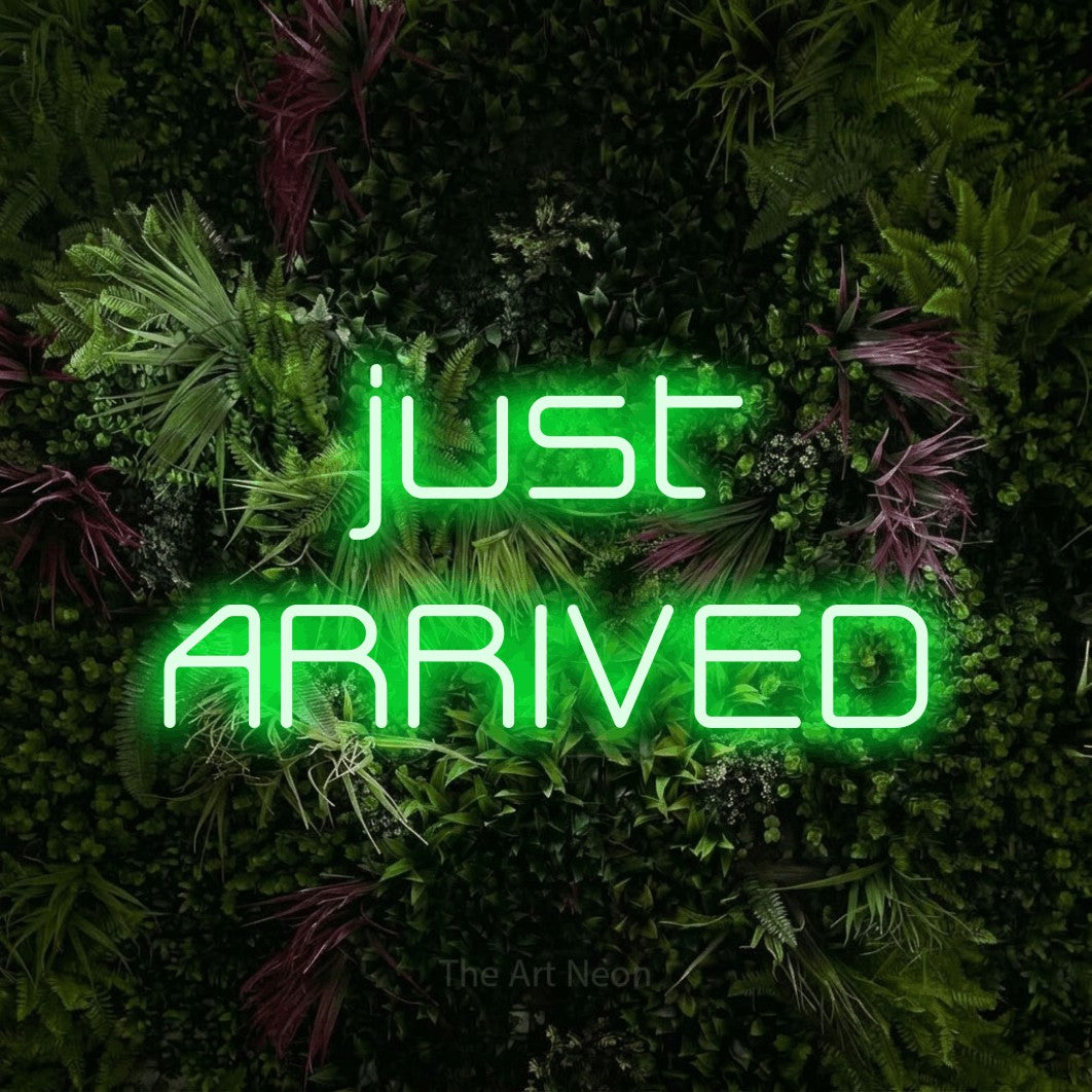 LED neon sign reading “just ARRIVED”, arranged in 2 lines.