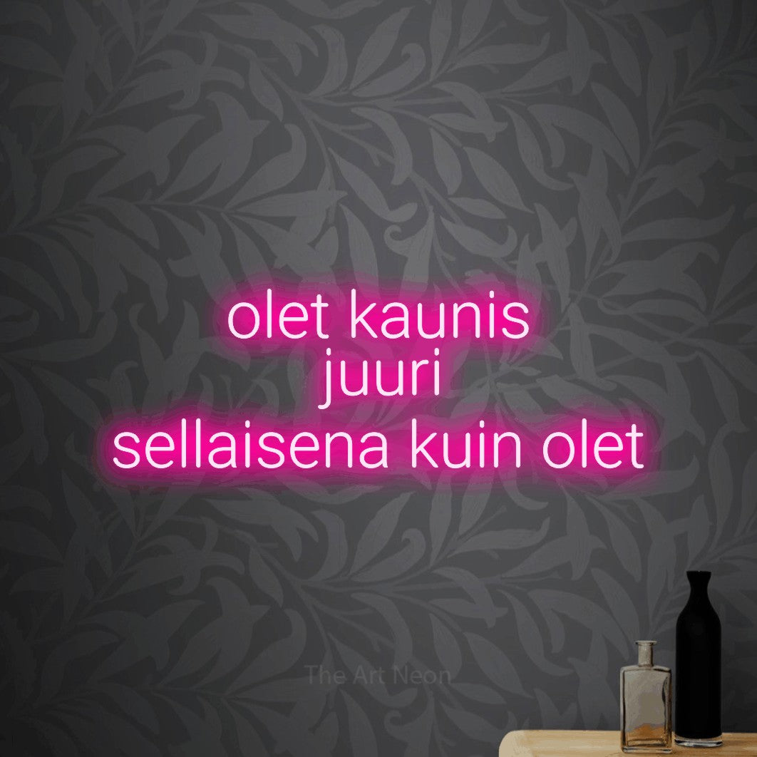 LED neon sign reading “olet kaunis juuri sellaisena kuin olet”, arranged in 3 lines.