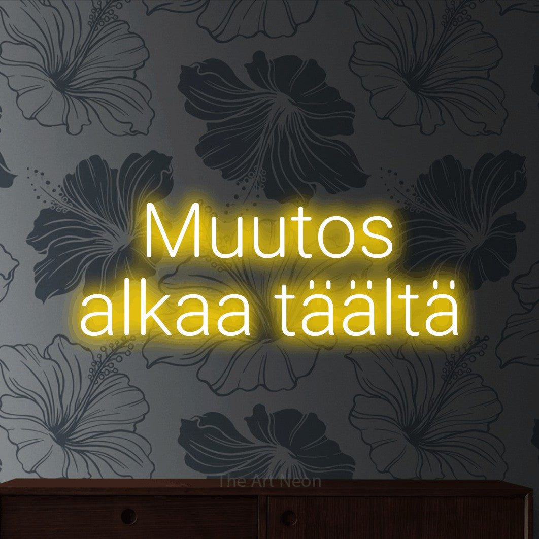LED neon sign reading “Muutos alkaa täältä”, arranged in 2 lines.