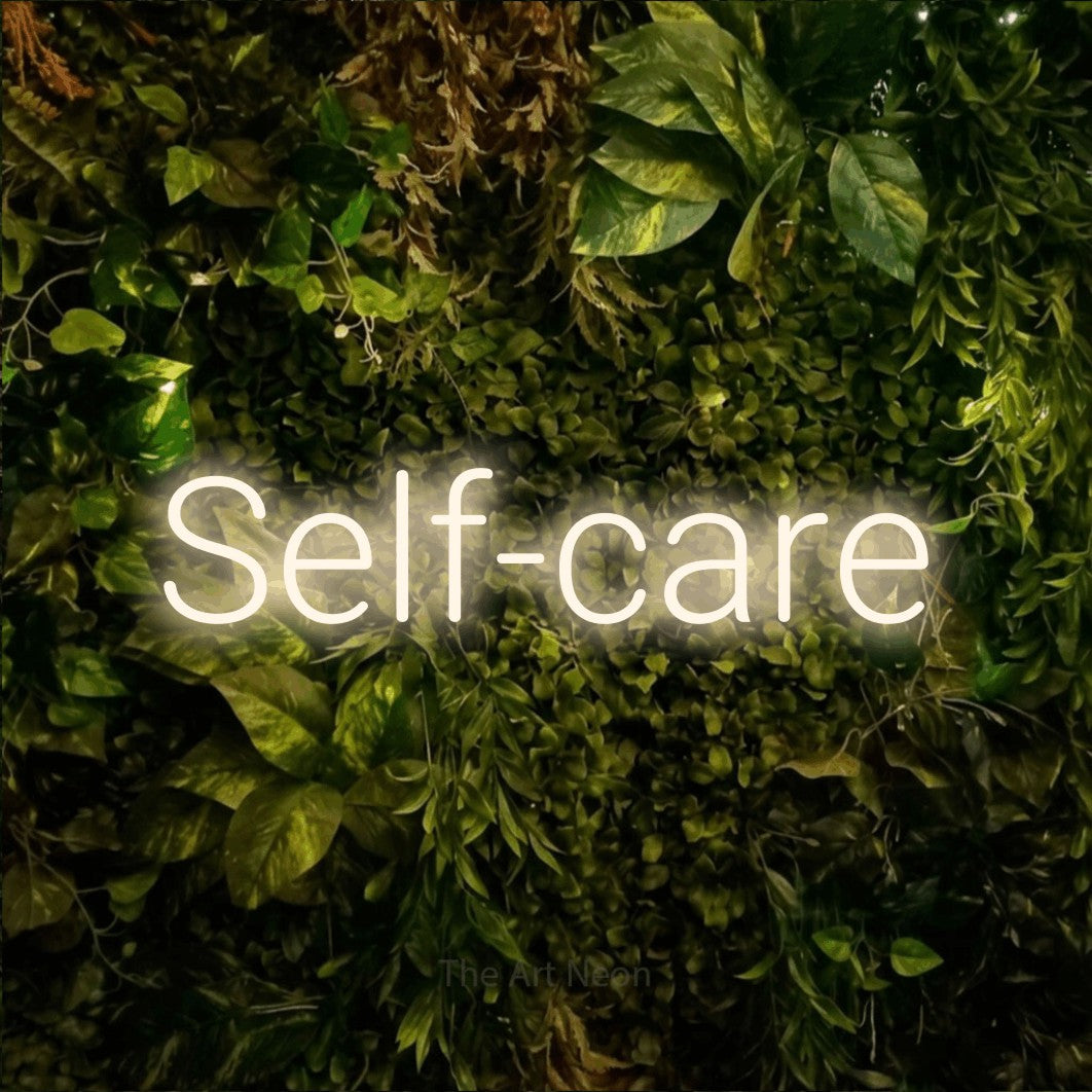 LED neon sign reading “Self-care”, arranged in a single line.