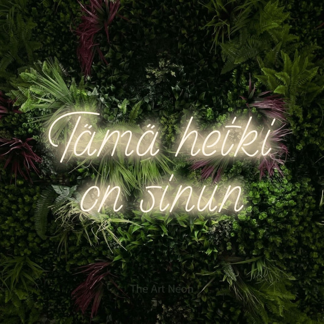 LED neon sign reading “Tämä hetki on sinun”, arranged in 2 lines.