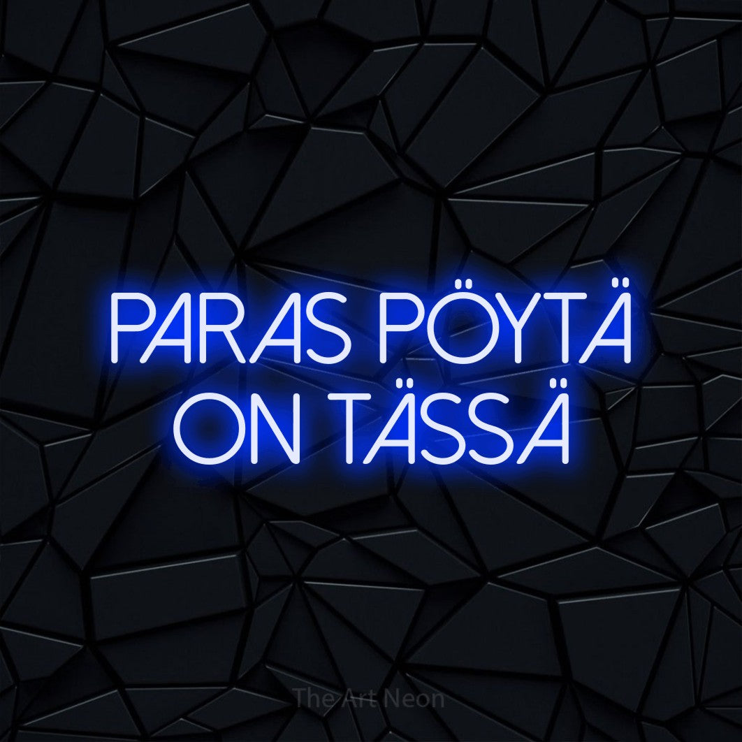 LED neon sign reading “Paras pöytä on tässä”, arranged in 2 lines.