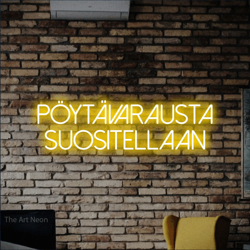 LED neon sign reading “Pöytävarausta suositellaan”, arranged in 2 lines.