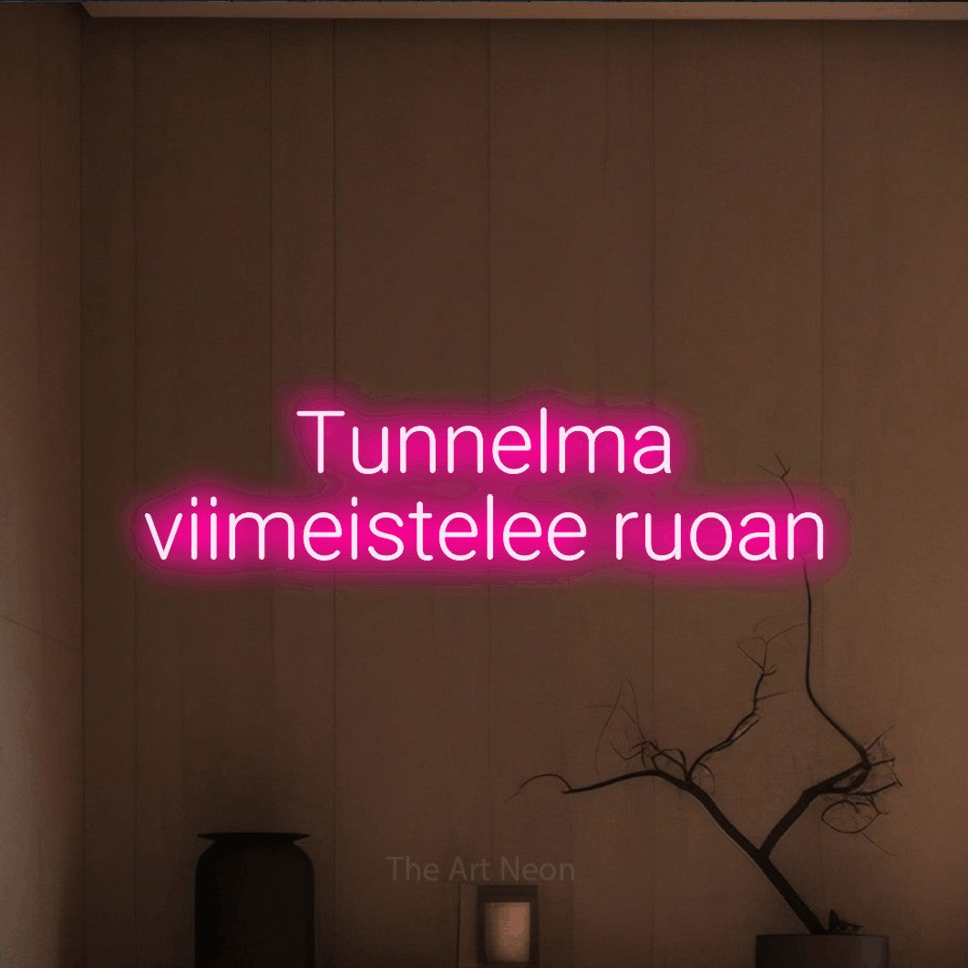 LED neon sign reading “Tunnelma viimeistelee ruoan”, arranged in 2 lines.
