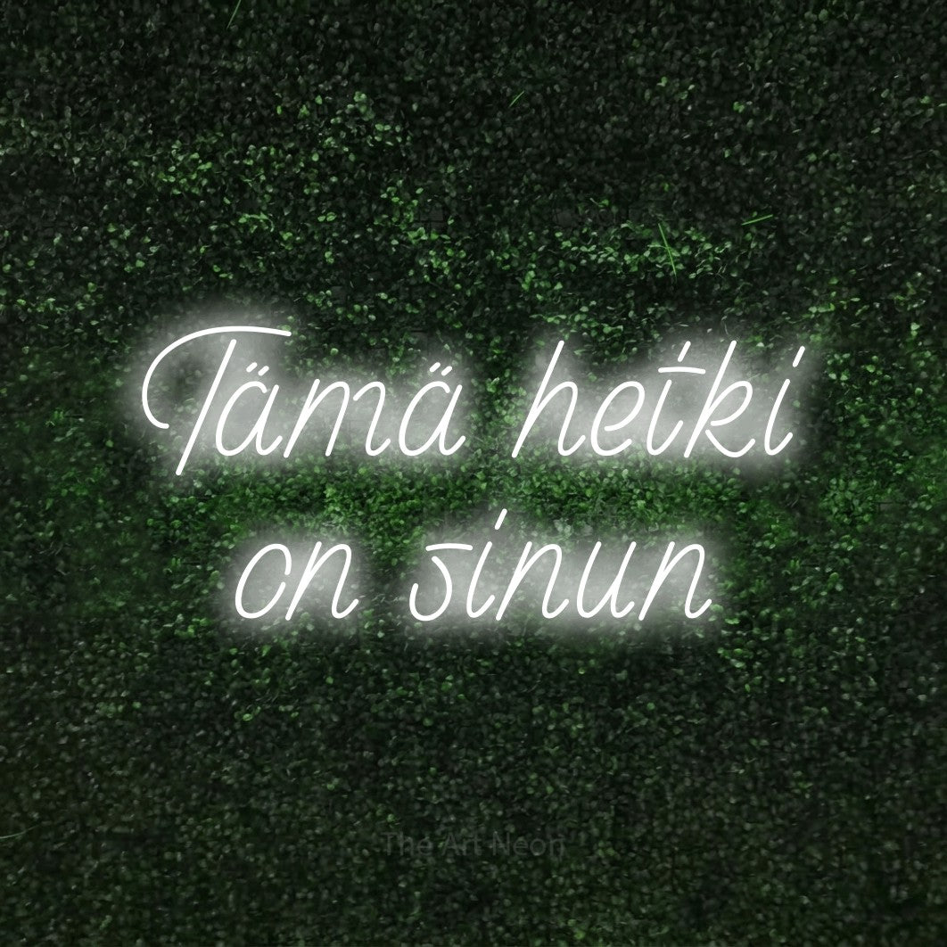 LED neon sign reading “Tämä hetki on sinun”, arranged in 2 lines.