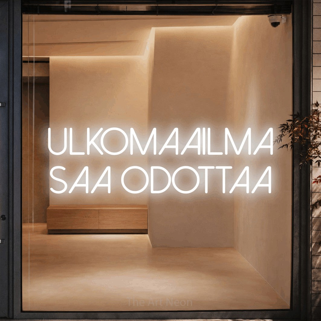 LED neon sign reading “Ulkomaailma saa odottaa”, arranged in 2 lines.