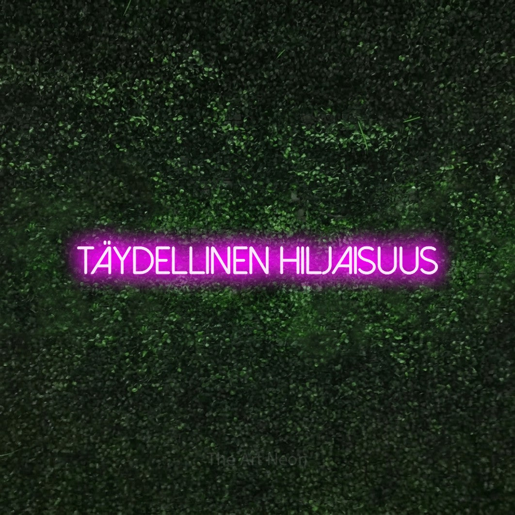 LED neon sign reading “täydellinen hiljaisuus”, arranged in a single line.