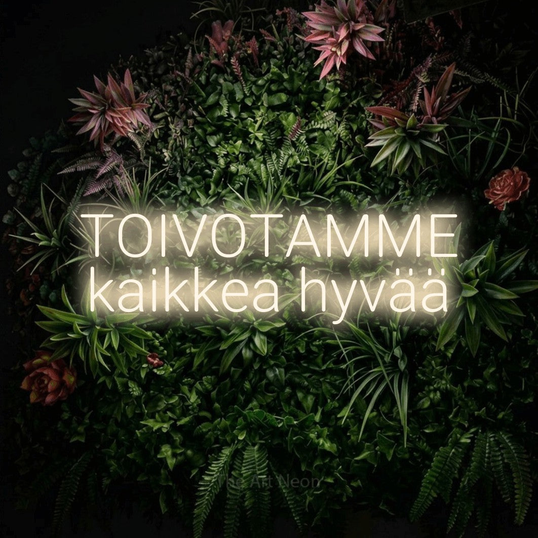 LED neon sign reading “TOIVOTAMME kaikkea hyvää”, arranged in 2 lines.