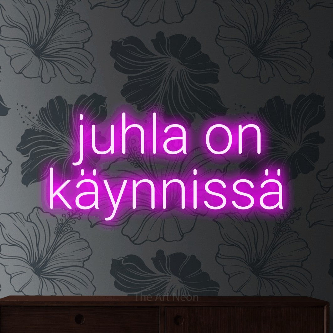 LED neon sign reading “juhla on käynnissä”, arranged in 2 lines.