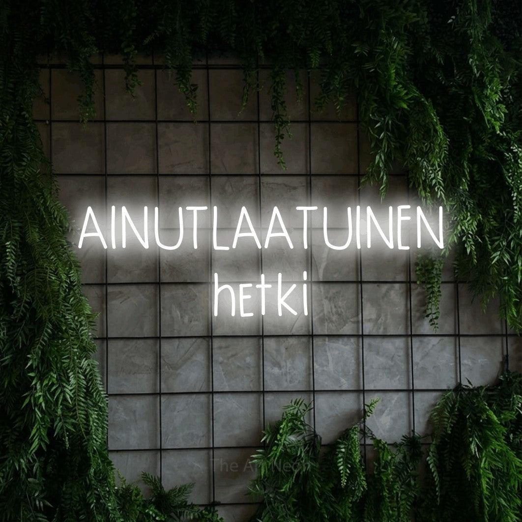 LED neon sign reading “AINUTLAATUINEN hetki”, arranged in 2 lines.