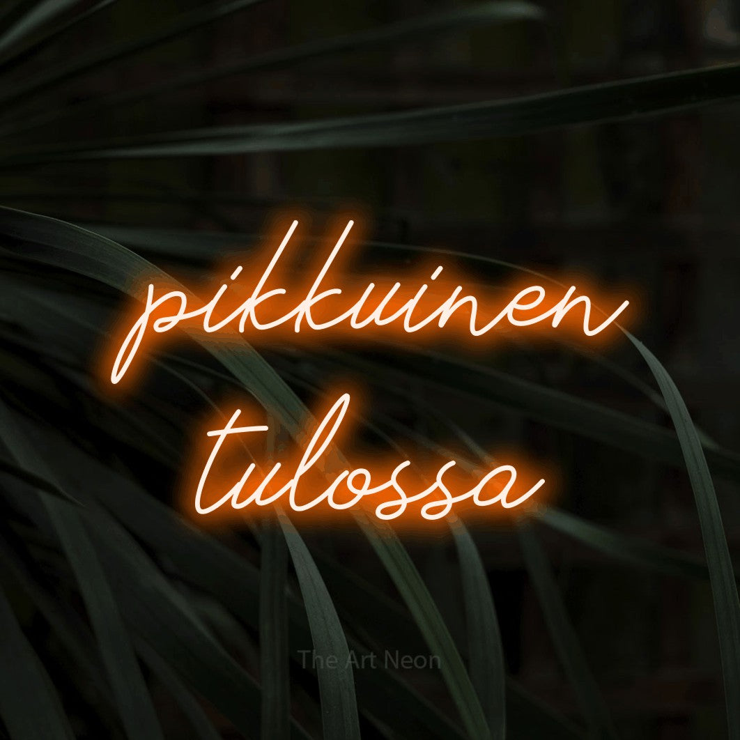 LED neon sign reading “pikkuinen tulossa”, arranged in 2 lines.