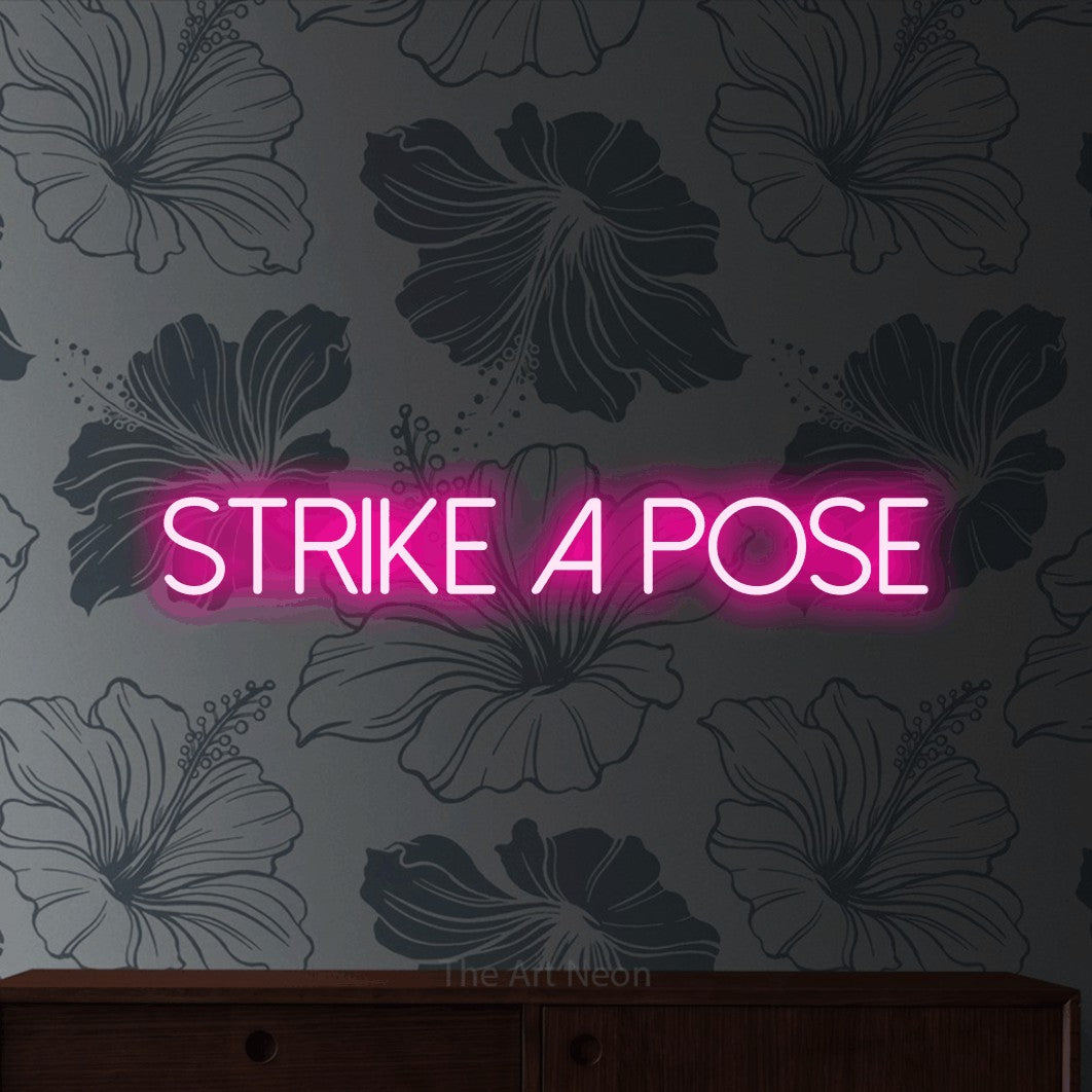 LED neon sign reading “Strike a pose”, arranged in a single line.