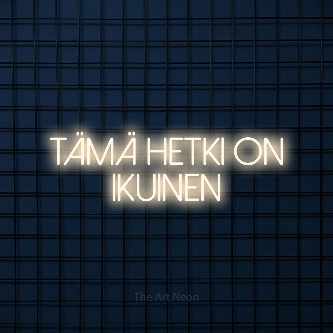 LED neon sign reading “Tämä hetki on ikuinen”, arranged in 2 lines.
