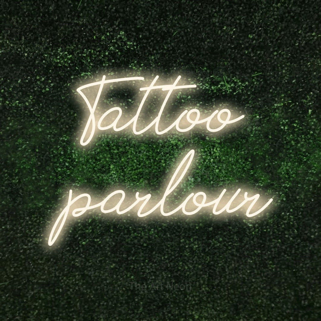 LED neon sign reading “Tattoo parlour”, arranged in 2 lines.